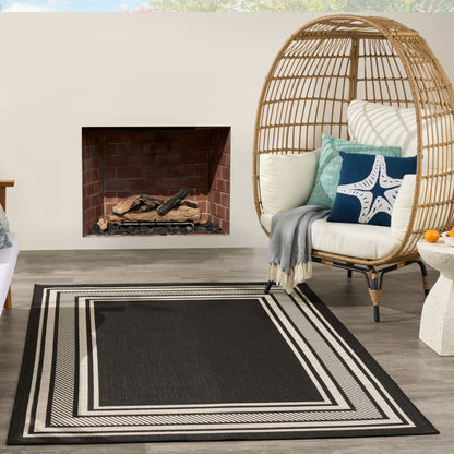Woven rattan egg chair with light cushions and blue starfish pillow, red brick fireplace, and a black-and-white striped rug.