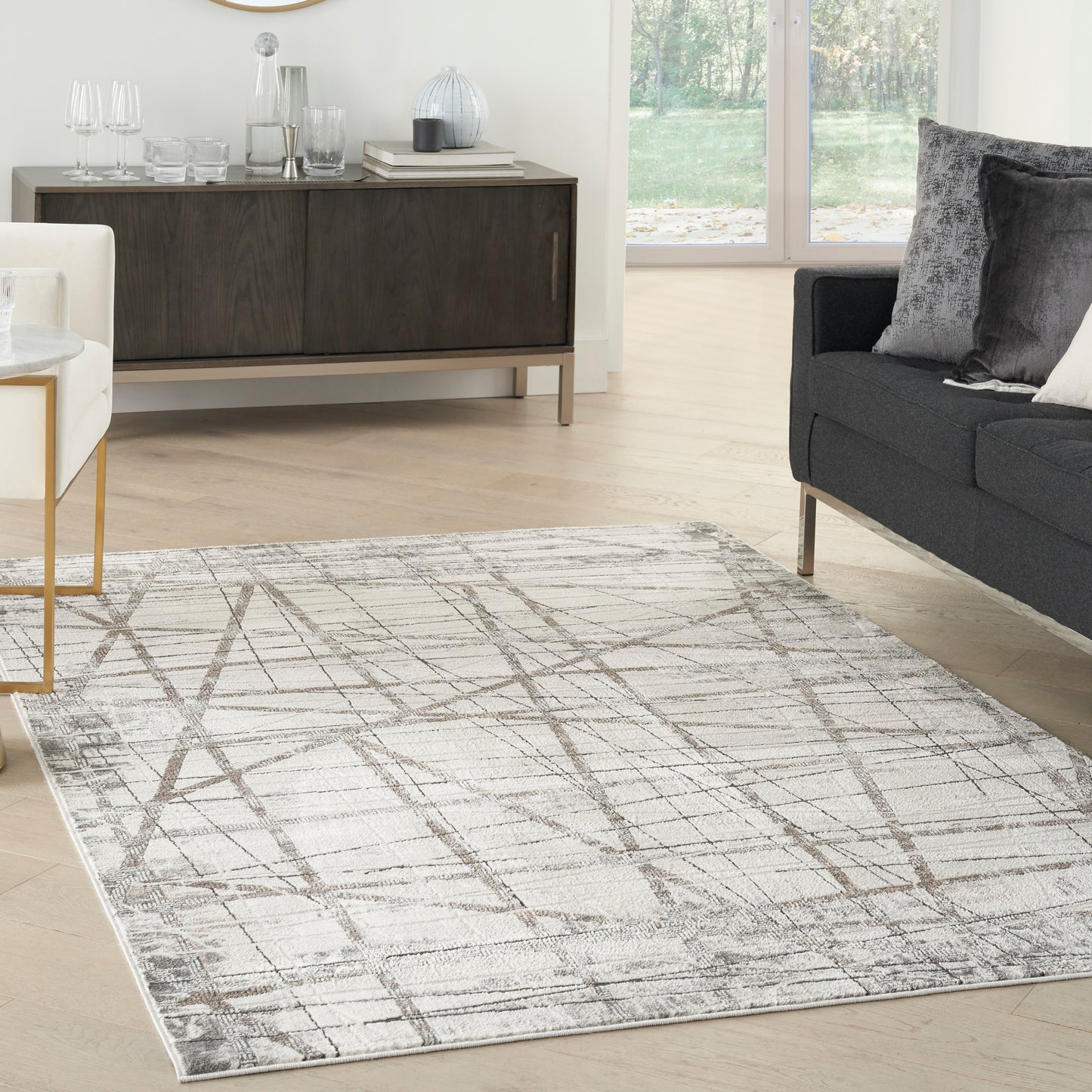 Rectangular beige area rug with gray abstract linear pattern, soft plush pile for a modern contemporary living room.