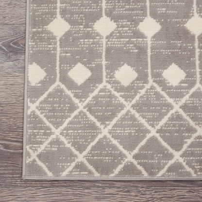 Gray runner rug with ivory geometric diamond lattice pattern and border on a wooden floor.