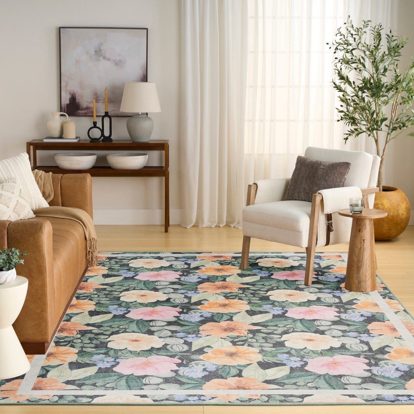 Living room with floral rug in teal, peach and pink, cream armchair, brown sofa, and wooden side table.