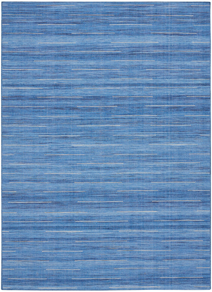 Blue flat-weave rug with random thin white dash lines for a modern coastal look.
