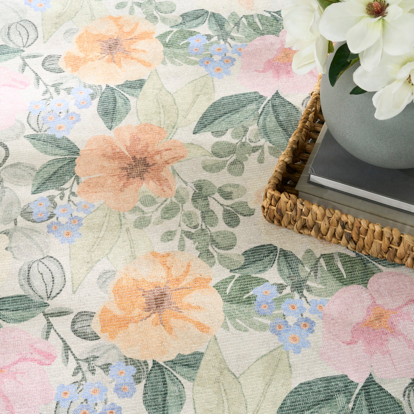 Pastel floral fabric pattern with peach & pink blooms, blue blossoms and green leaves; woven basket with white flowers.
