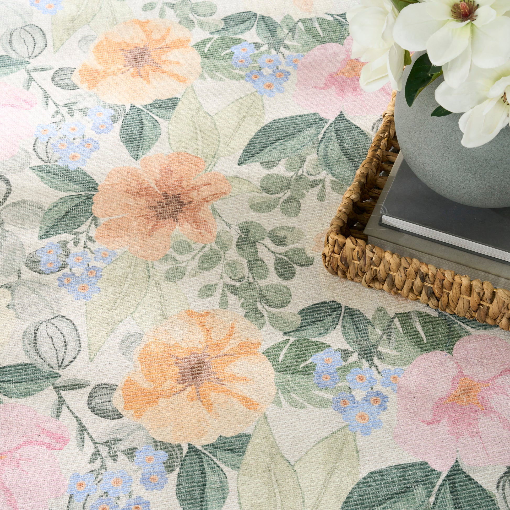 Pastel floral fabric pattern with peach & pink blooms, blue blossoms and green leaves; woven basket with white flowers.