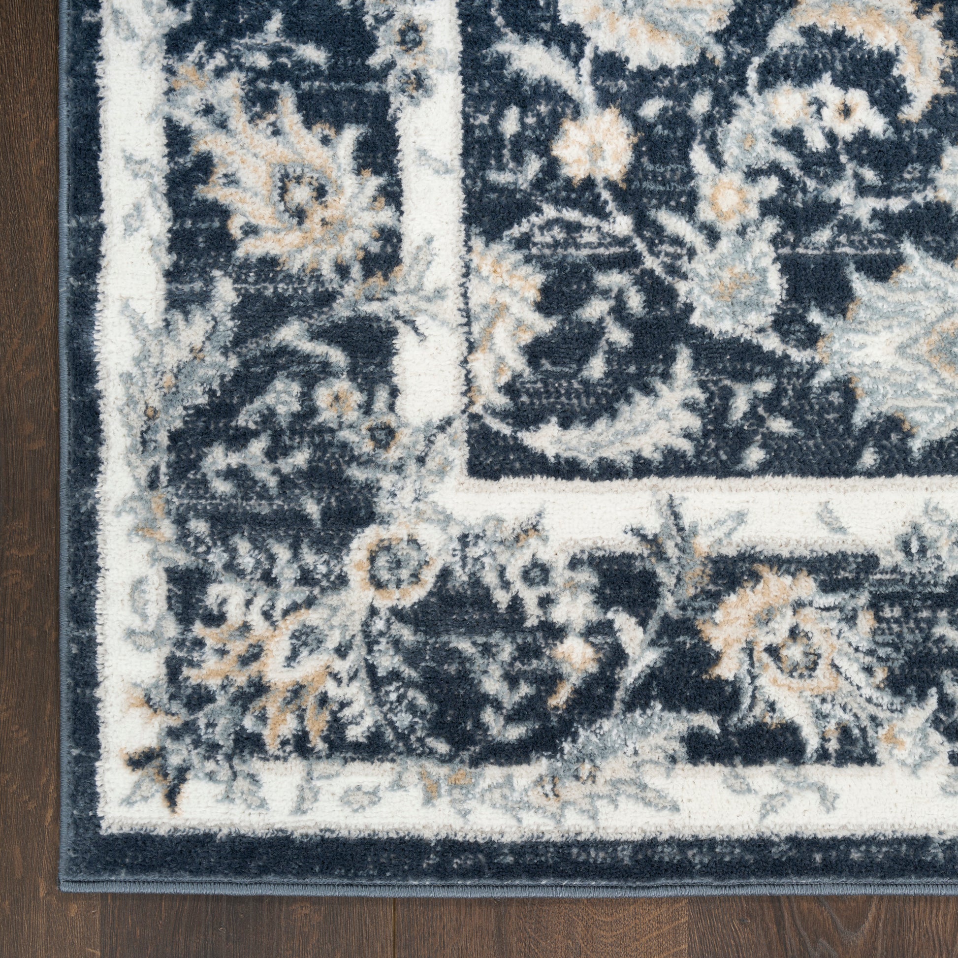 Rectangular navy rug with ivory border and beige floral motifs in a traditional oriental pattern.