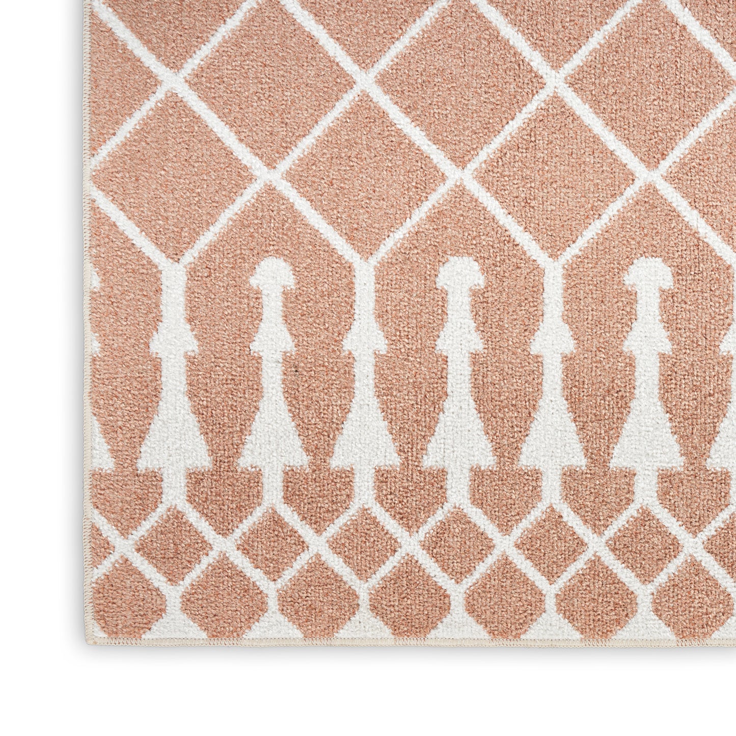 Peach shag rug with white lattice diamonds and a row of white dress-shaped silhouettes for modern geometric decor.