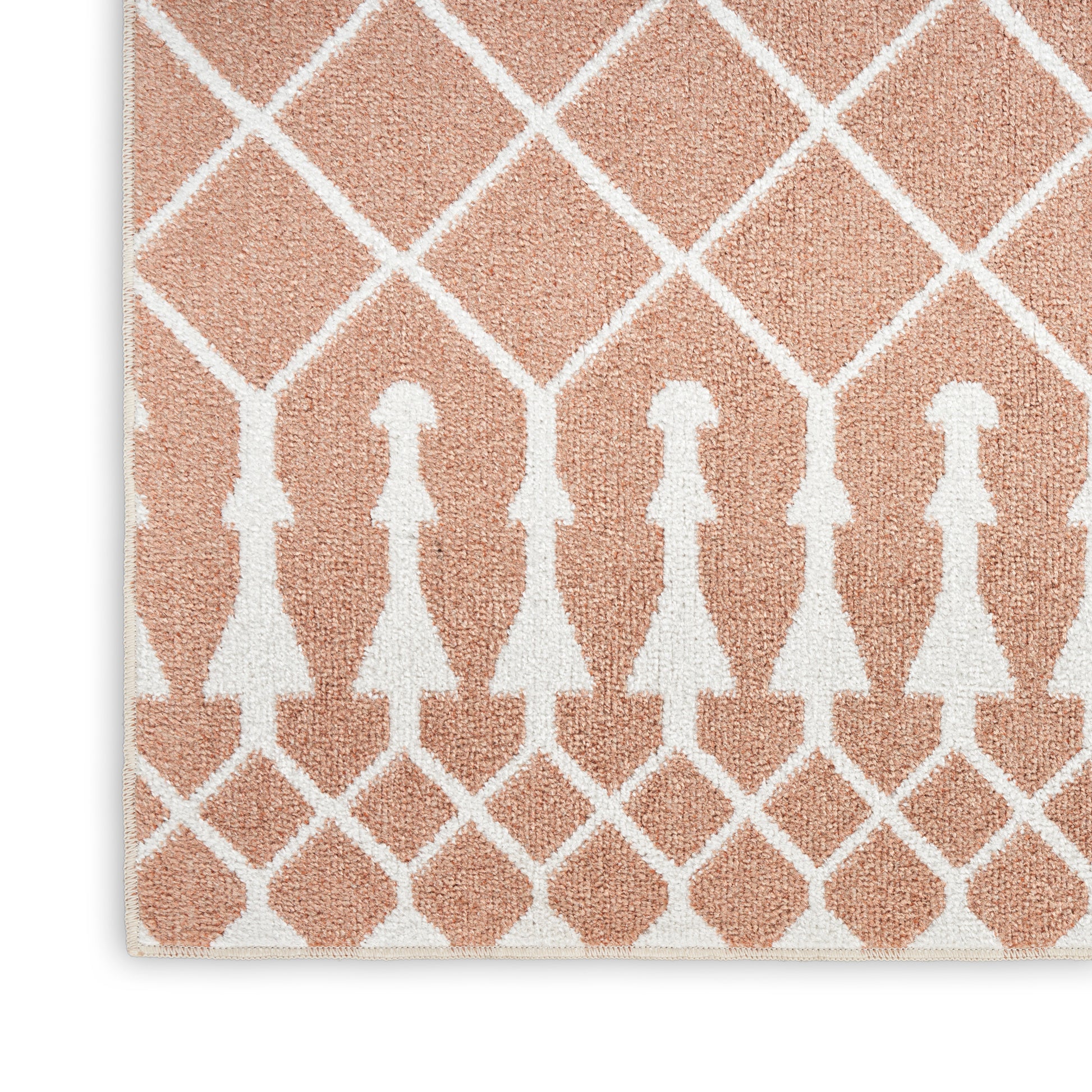 Peach shag rug with white lattice diamonds and a row of white dress-shaped silhouettes for modern geometric decor.