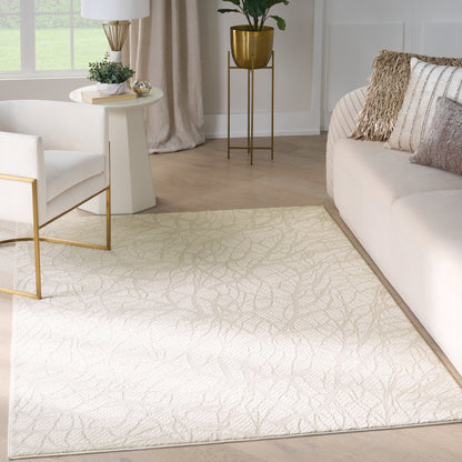 Cream textured area rug with leaf-like pattern on light wood floor; white sofa and armchair with gold accents in a living room.