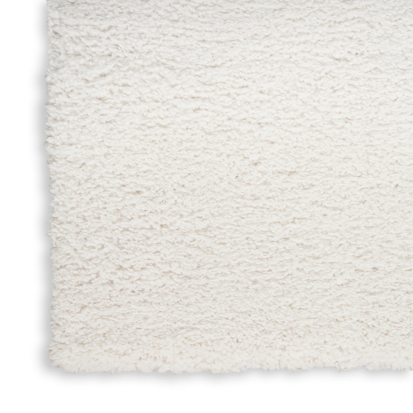Cream shag rug close-up with fluffy plush pile and straight edge; cozy home decor.
