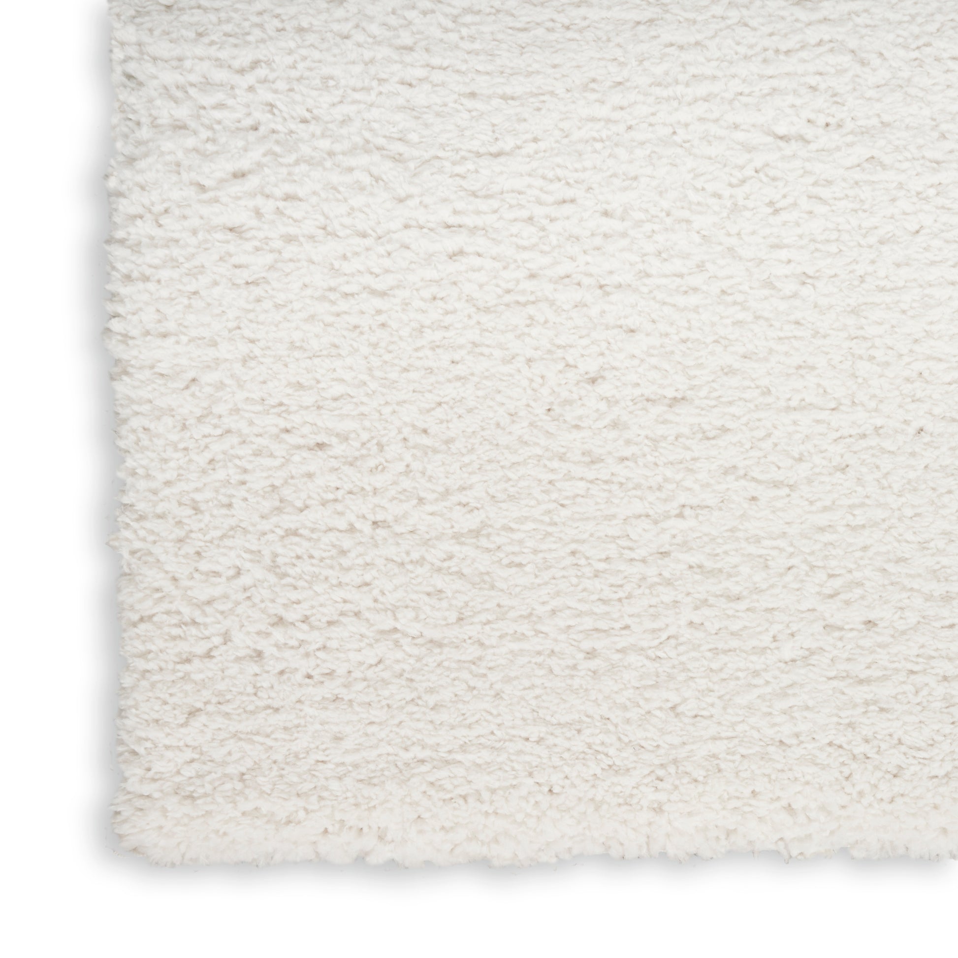 Cream shag rug close-up with fluffy plush pile and straight edge; cozy home decor.