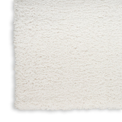 Cream shag rug close-up with fluffy plush pile and straight edge; cozy home decor.