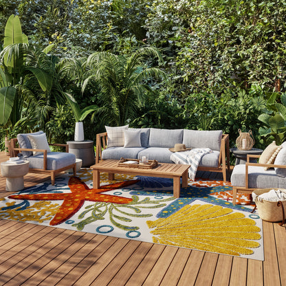 Colorful tropical outdoor rug on a patio with lush green plants.