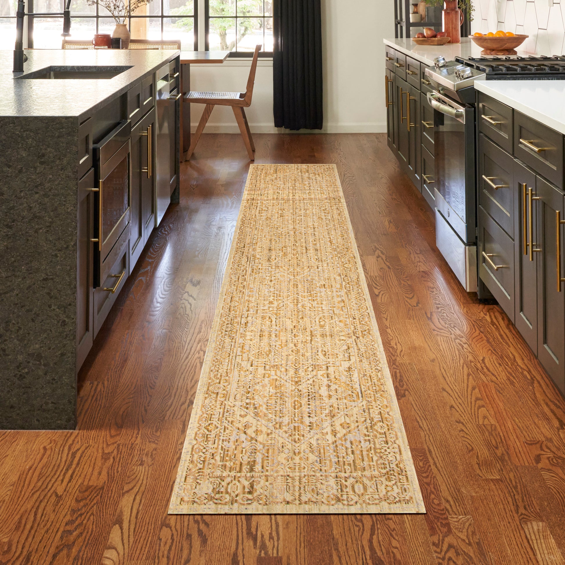 Beige oriental-patterned runner rug on dark hardwood kitchen floor between black cabinets.
