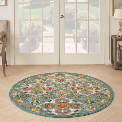 Round teal boho rug with vibrant multicolor floral motif on light wood entryway floor.