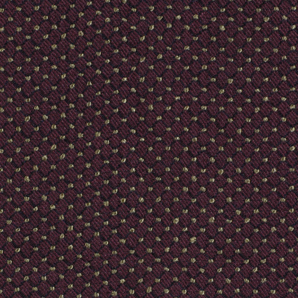 Close-up of burgundy woven upholstery fabric with tiny pale yellow dots; fine dotted pattern.