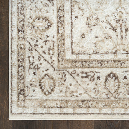 Rectangular plush ivory-beige traditional oriental area rug with brown floral border on dark wood floor.