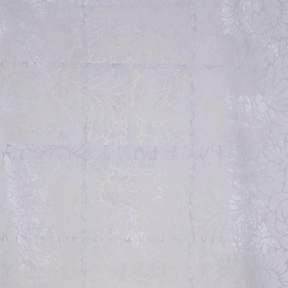 Soft lavender lace fabric with floral patterns and subtle patchwork texture.