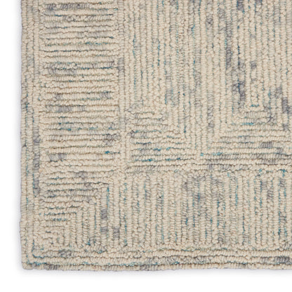 Beige loop-pile rug with pale blue-gray geometric pattern and border.
