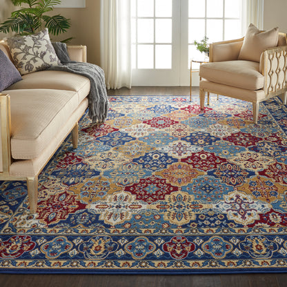 Cozy living room with an ornate blue, red, gold oriental area rug on the floor, with cream fabric sofas and light wood chairs.