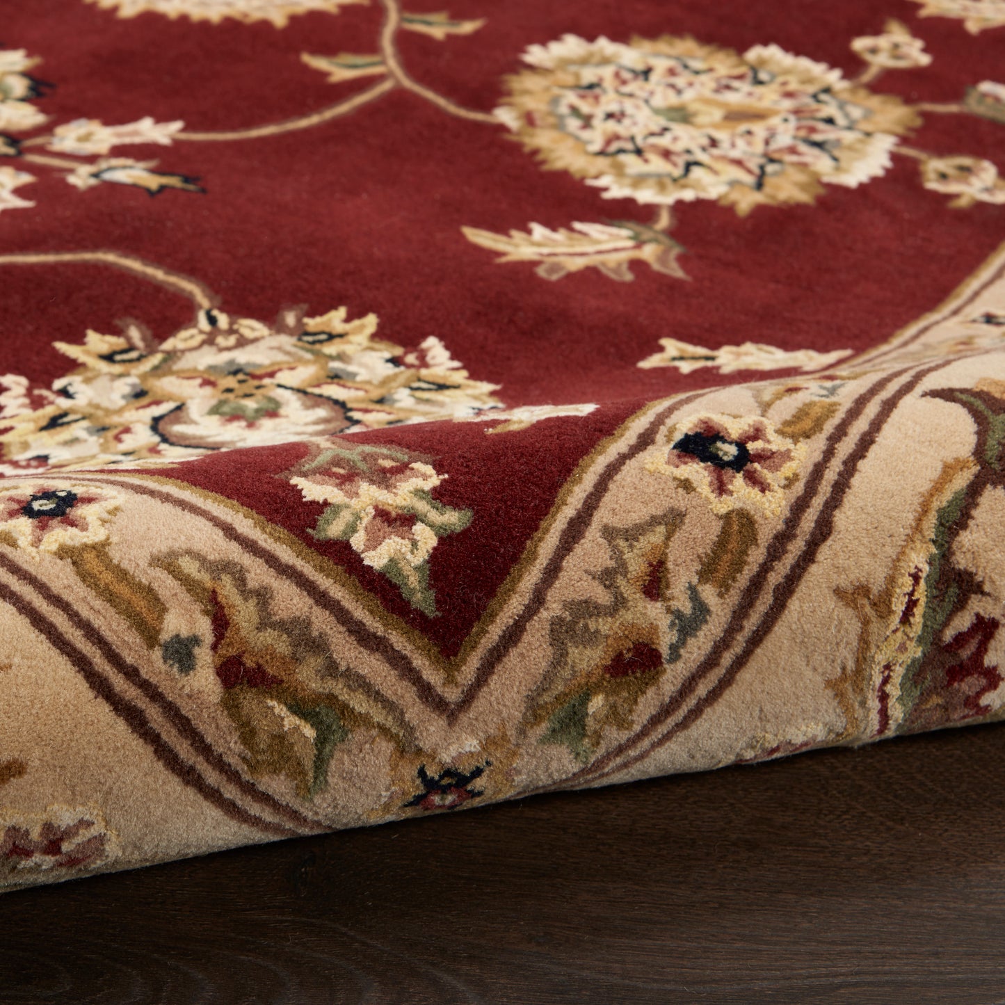 Rectangular Oriental rug with burgundy field, beige border & cream floral motifs.