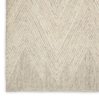Beige rug close-up with cream chevron zigzag pattern in a tufted textured pile.