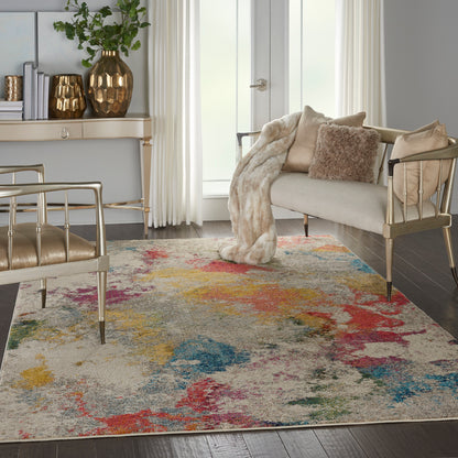 Glam mid-century living room with gold metal chairs, beige sofa, plush throw, colorful abstract rug & greenery.
