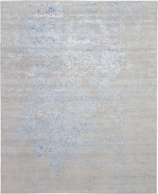 Rectangular beige area rug with pale blue-gray abstract marbling; modern coastal style.