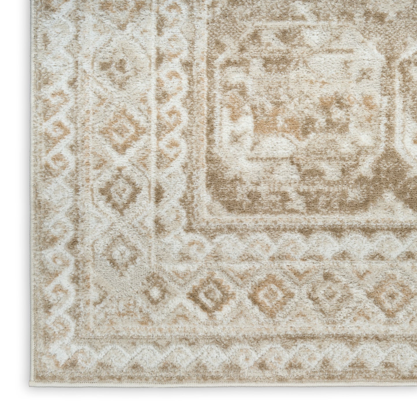 Beige and ivory rug with distressed antique motifs and geometric borders; rectangular shape, soft plush finish.