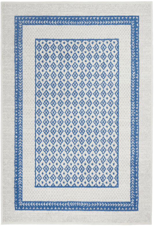 Cream rug with a blue diamond trellis center, flanked by dual blue borders and a leafy outer edge.