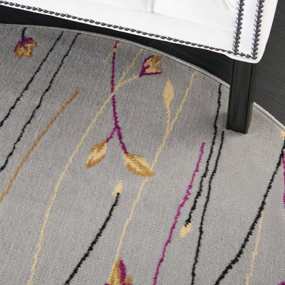 Gray textured area rug with abstract gold and purple leaf stems, black and beige lines, beside a black furniture leg.