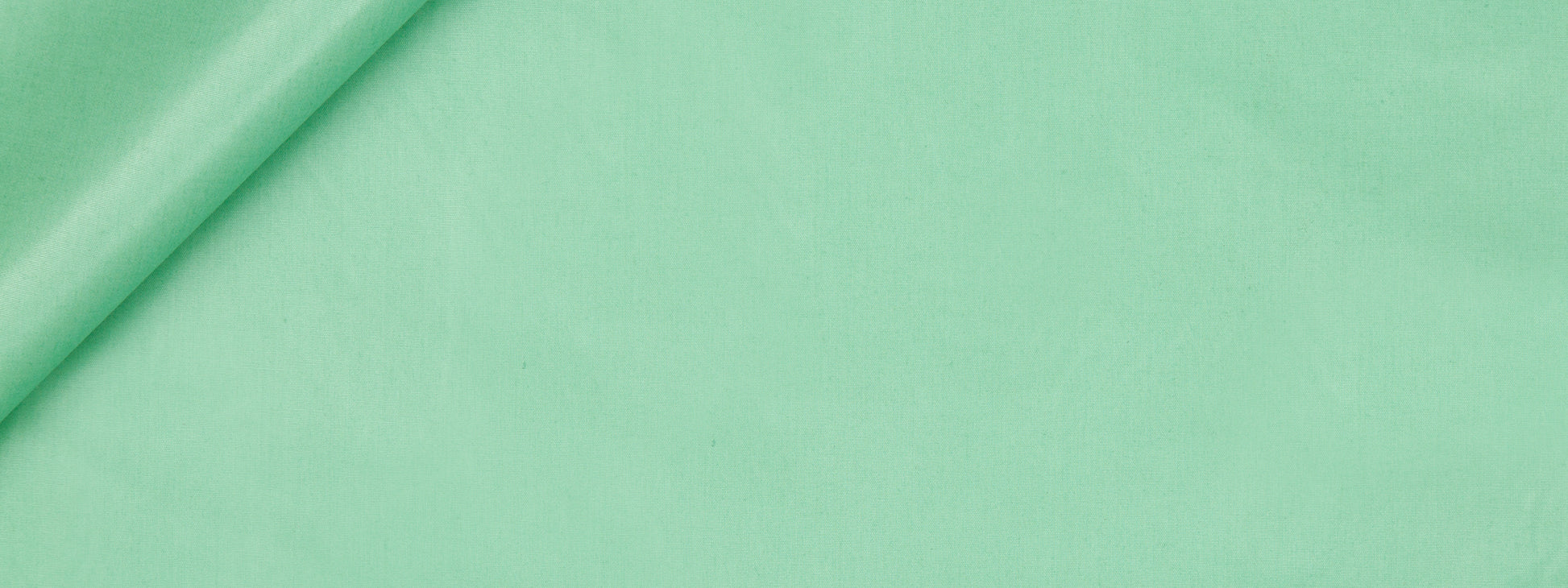 Mint green fabric roll on a solid green background; smooth textile ideal for sewing or crafts.