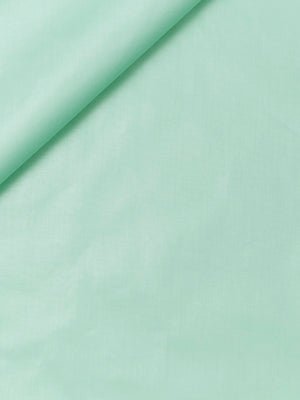 Mint green fabric with a top-left diagonal fold, smooth lightweight textile.