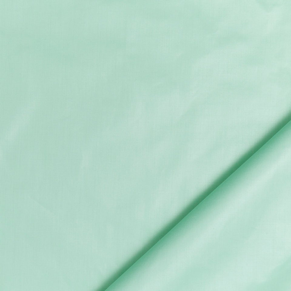 Mint green fabric with a diagonal fold, soft cotton sheet.