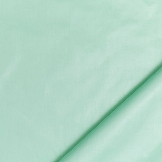 Mint green fabric with a diagonal fold, soft cotton sheet.