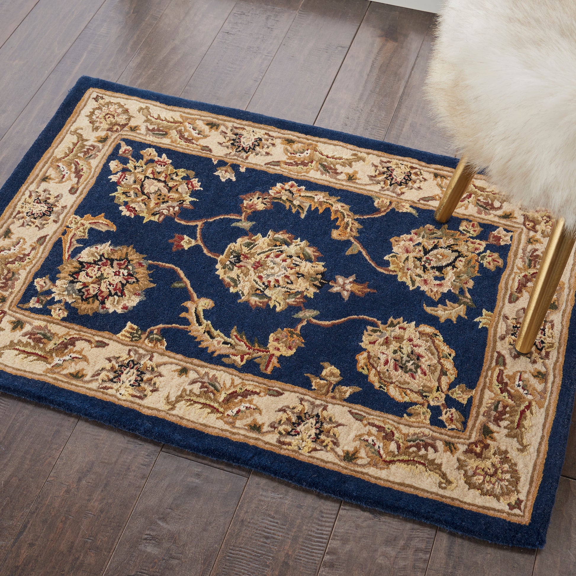 Rectangular navy blue & cream floral border oriental rug on dark wood floor; traditional style.