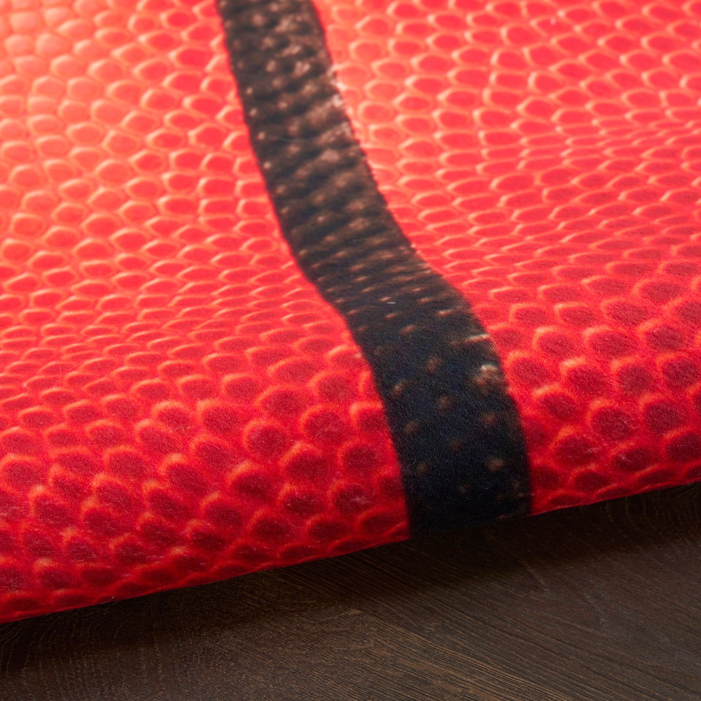 Close-up of red pebble-grain leather with a black diagonal strap.
