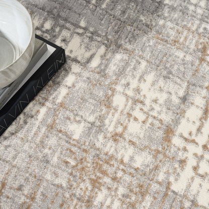 Beige and gray abstract-pattern area rug with a ceramic bowl on a stack of books.