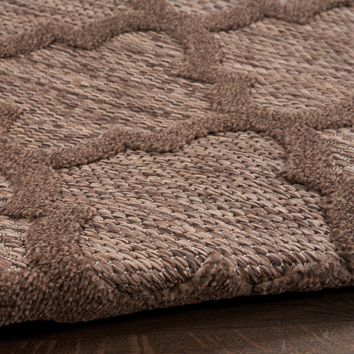 Brown woven jute rug with raised circular tufted motif, rustic textured pattern for living spaces.