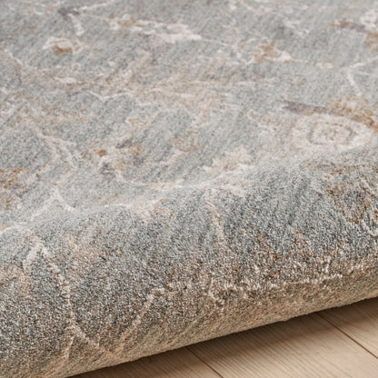 Grey area rug with ivory abstract motif, softly textured, rectangular and rolled on a light wood floor.