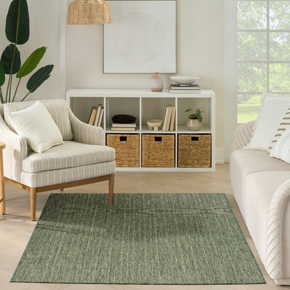 Neutral living room with cream striped armchair, white sofa, green woven rug, white cubby storage with wicker baskets.