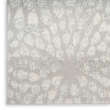 Beige textured rug with a raised dot sunburst motif; decorative jacquard/embossed weave.
