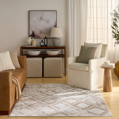Neutral living room with brown leather sofa, cream armchair, beige rug, wooden console, & window with sheer curtains.