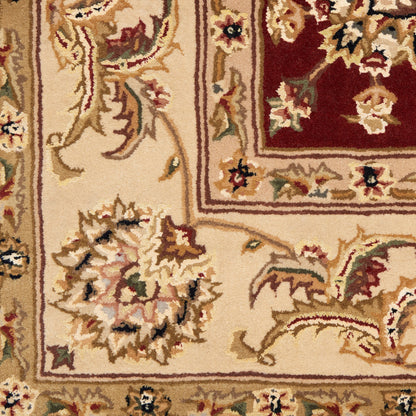 Beige oriental rug with red central medallion and ornate floral border; gold, cream and burgundy tones.