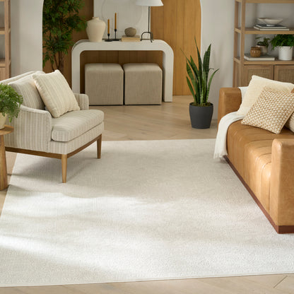 Cozy modern living room with beige fabric armchair, tan leather sofa, rug, wood floors, white curved console, and plants.