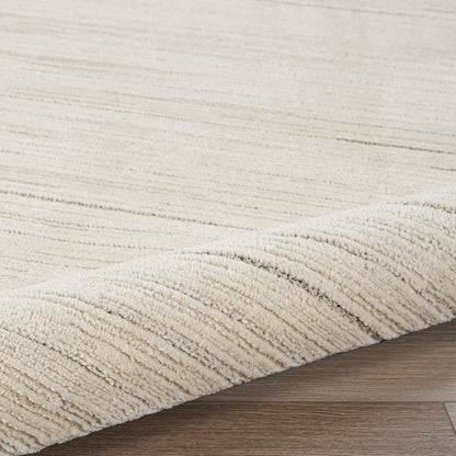 Cream textured runner rug with subtle stripes, partially rolled on a light wooden floor; plush, neutral living-room rug.