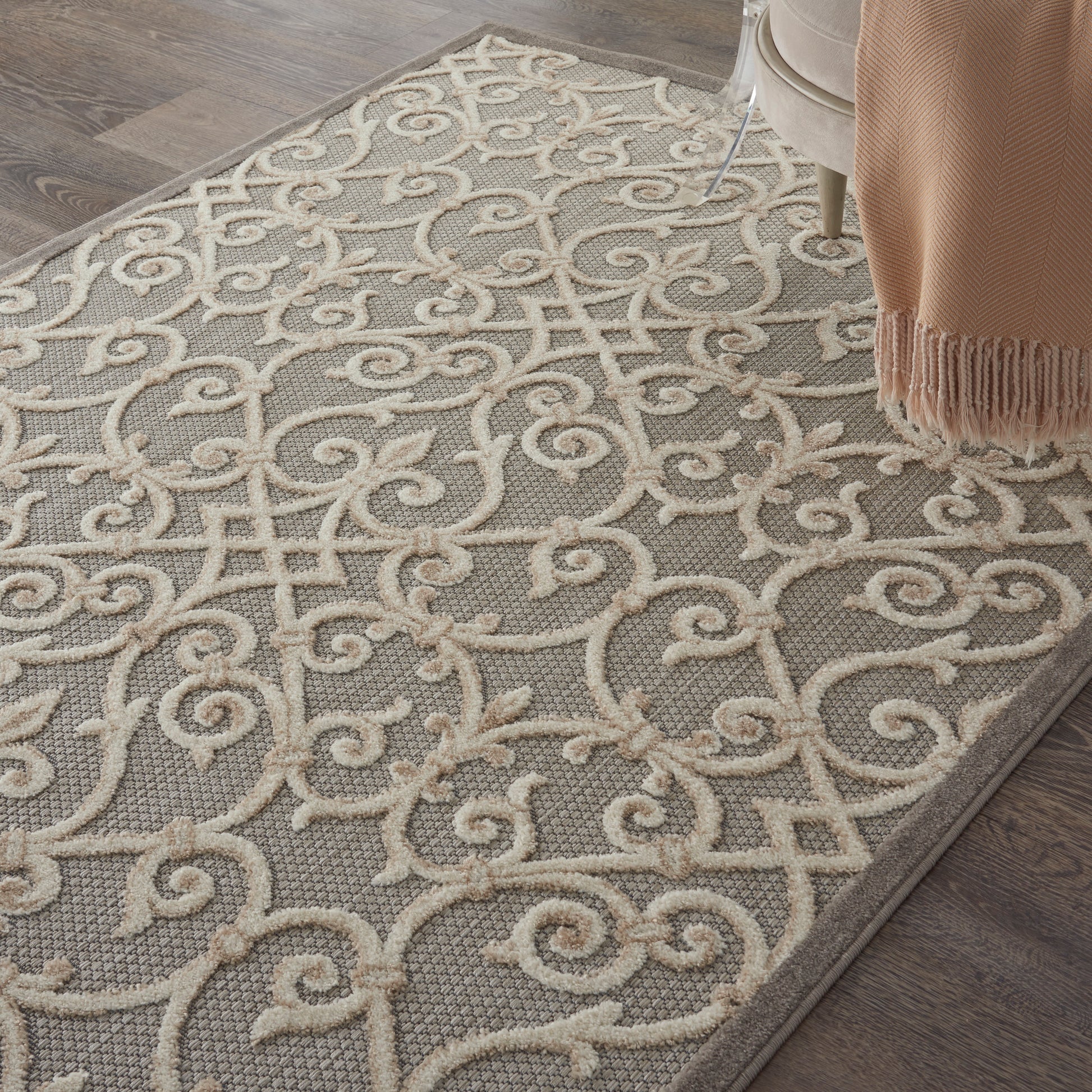 Gray rectangular area rug with ivory scrolling damask pattern; textured loop pile, elegant living room style.