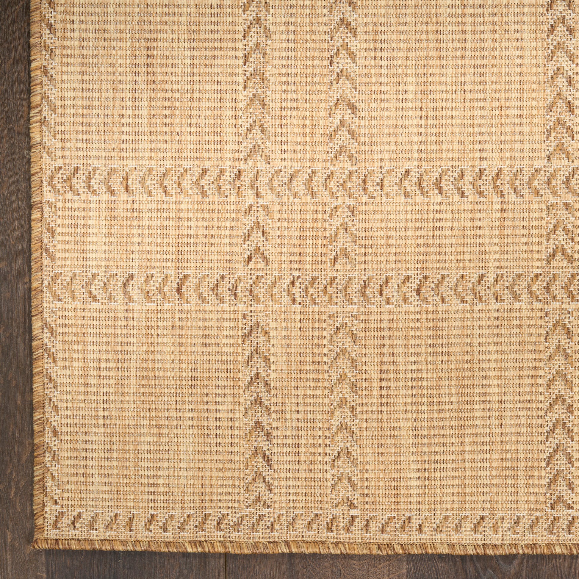 Natural jute rug with geometric panel blocks, braided borders and fringe; rectangular beige that suits living spaces.