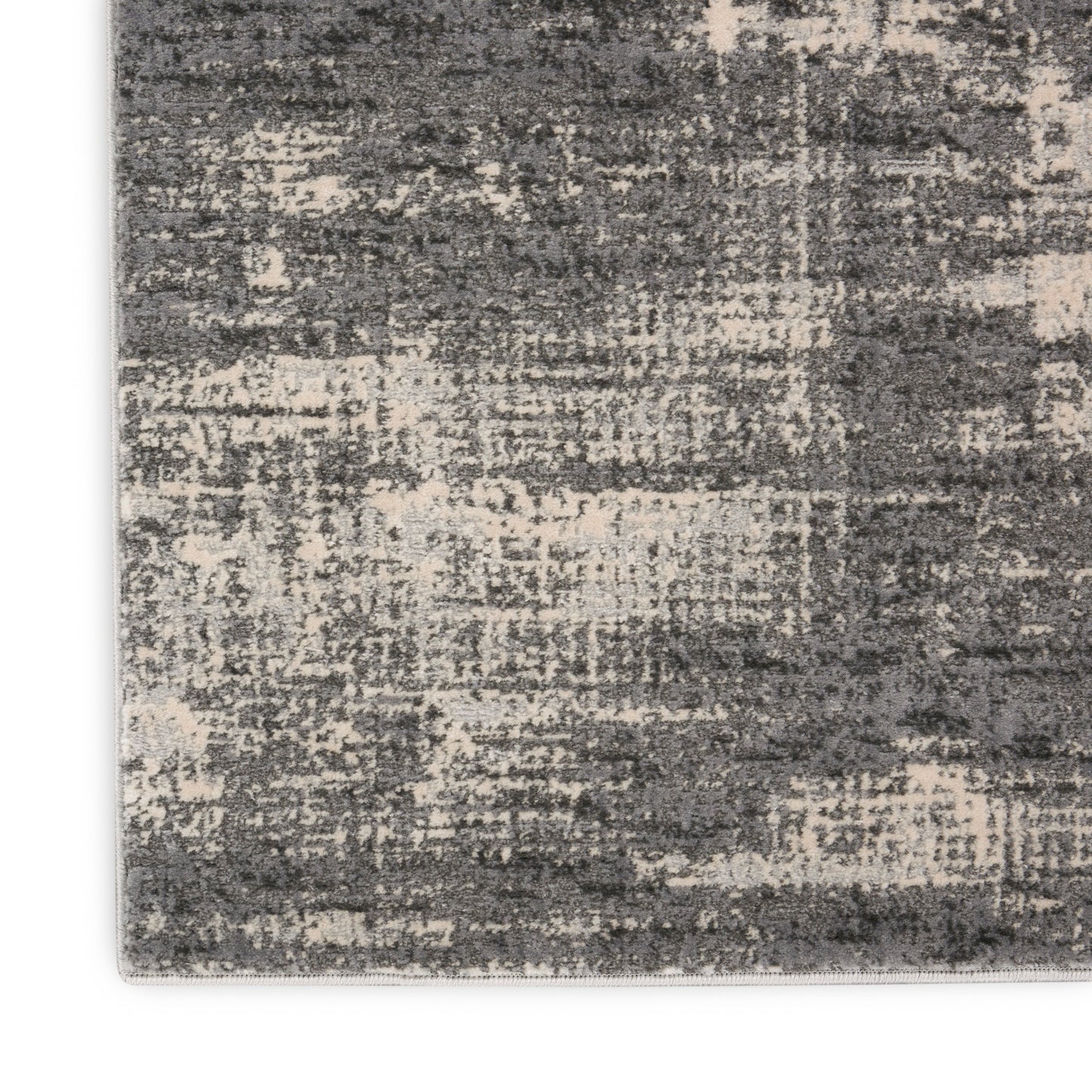 Gray and beige distressed abstract rug with textured pattern and low pile.
