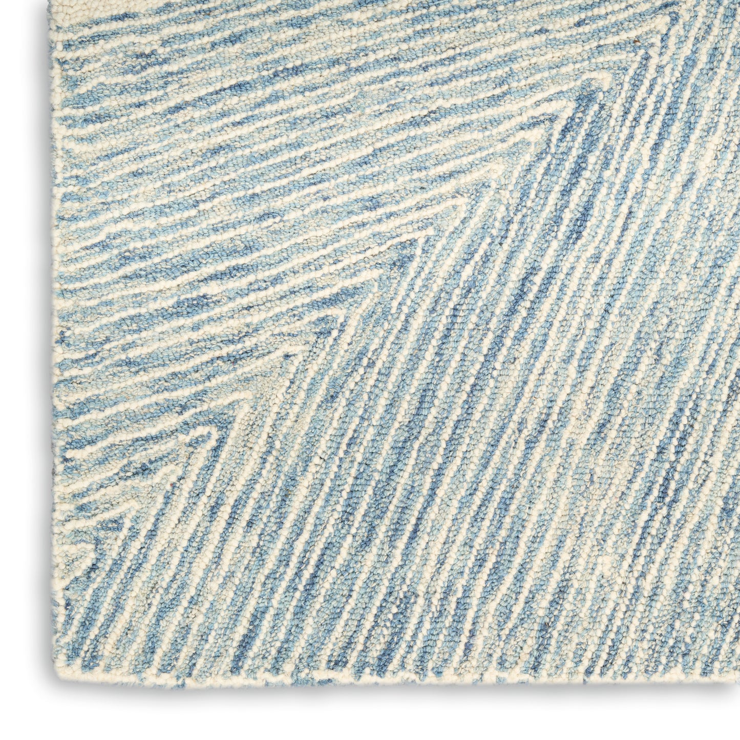 Close-up of a blue and white textured rug with diagonal ridged stripes and soft pile.