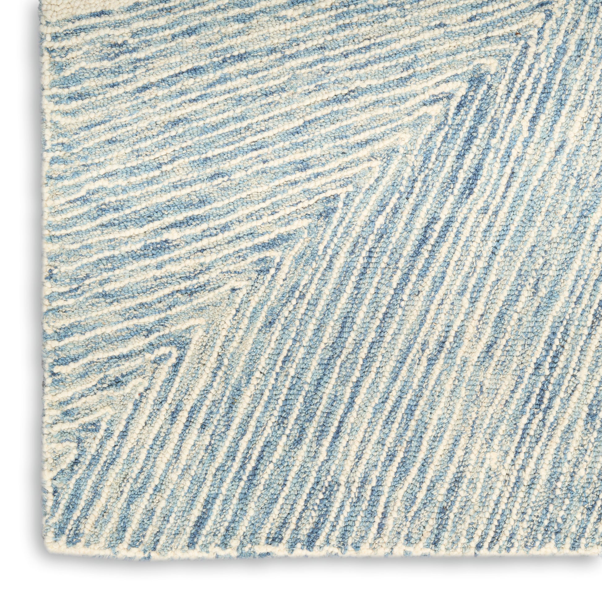 Close-up of a blue and white textured rug with diagonal ridged stripes and soft pile.
