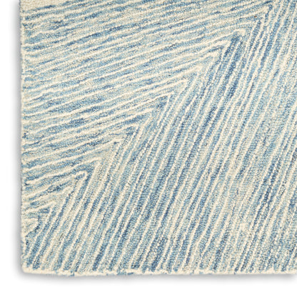 Close-up of a blue and white textured rug with diagonal ridged stripes and soft pile.